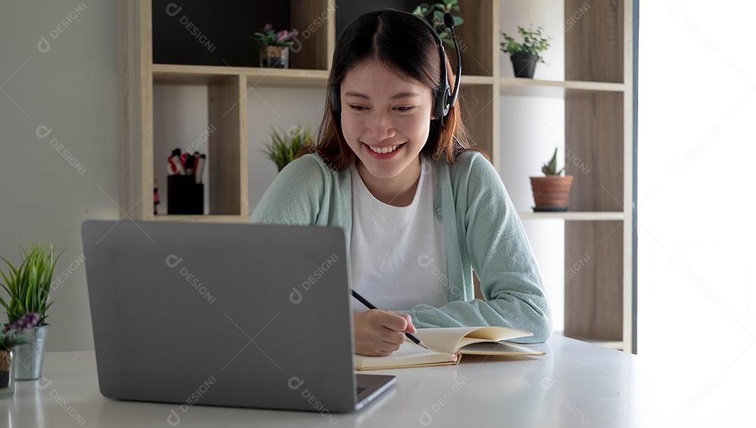 Mulher jovem feliz em fones de ouvido falando olhando para laptop