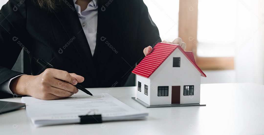 Mãos femininas segurando modelo de casa, pequeno brinquedo branco em miniatura