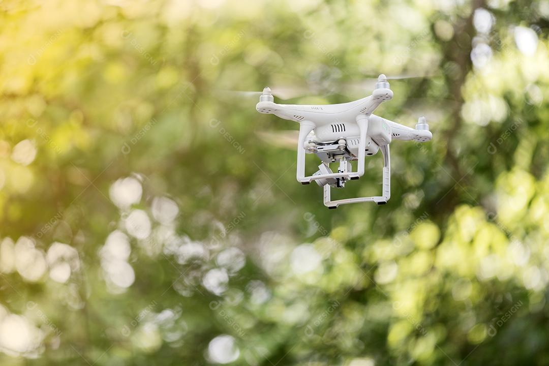 Drone branco quad copter com câmera digital de alta resolução voando no céu azul, foco suave
