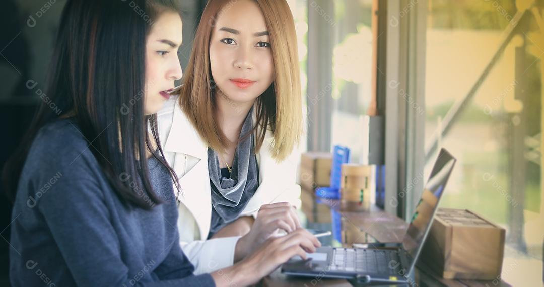 Duas mulheres de negócios asiáticas usando notebook trabalhando e discussão do importante contrato no escritório