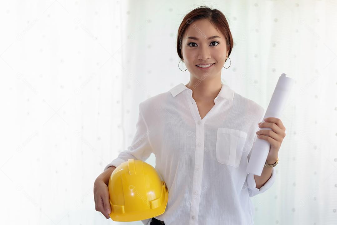Engenharia de mulheres asiáticas segurando plantas, capacete para trabalhar no escritório e fundo branco