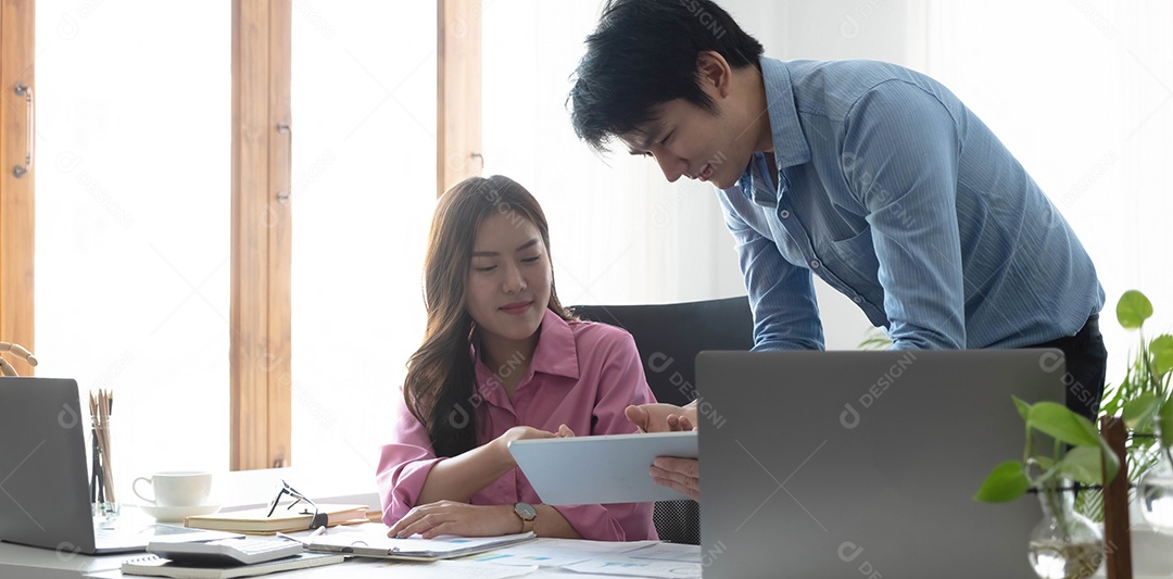 Empresário e empresária discutindo novo projeto de negócios em tablet