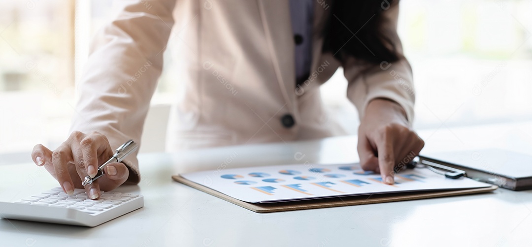 A mulher de negócios está calculando a renda-despesa e analisando