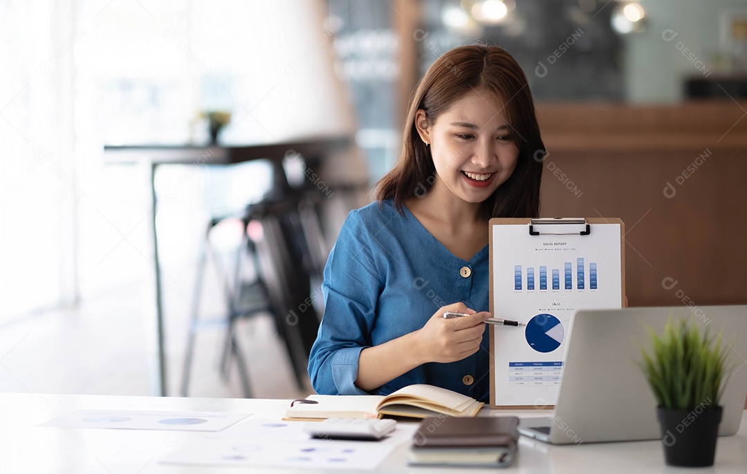 Retrato de uma jovem asiática trabalhando no laptop no escritório