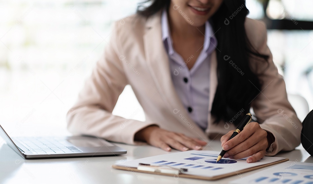 Empresária apontando caneta para gráfico de dados, estimando lucro