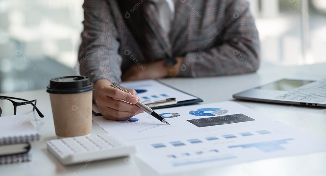 Empresária apontando caneta para os gráficos