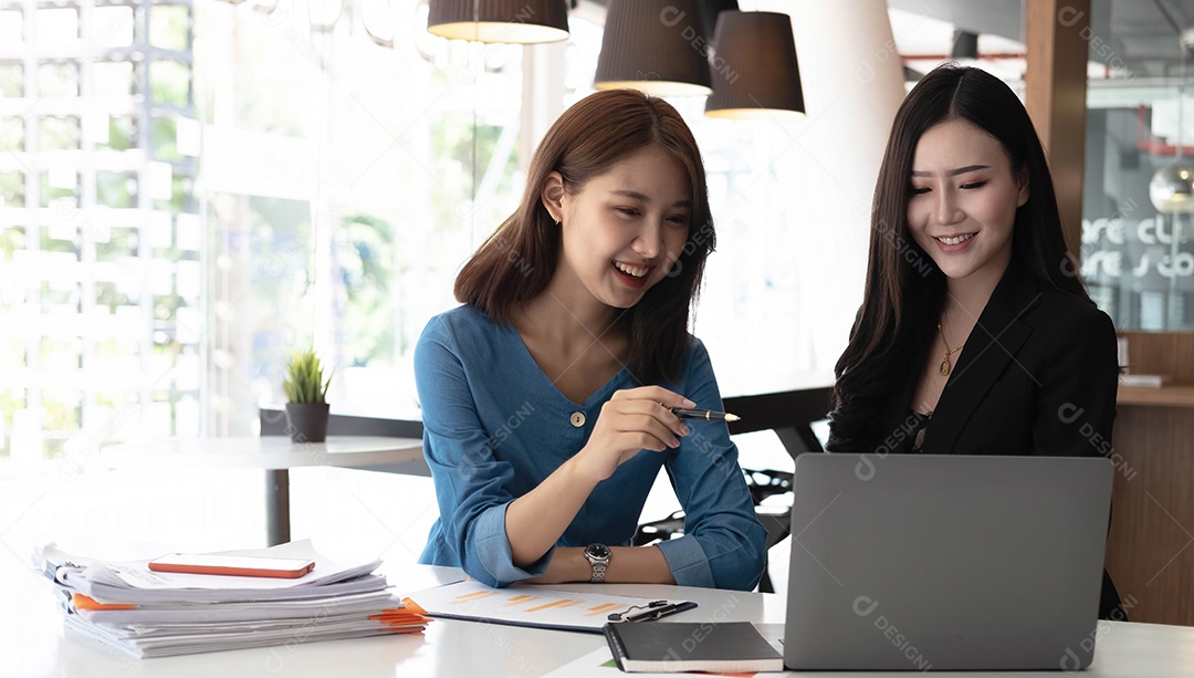 Duas mulheres de negócios asiáticas trabalham juntas para fazer o trabalho