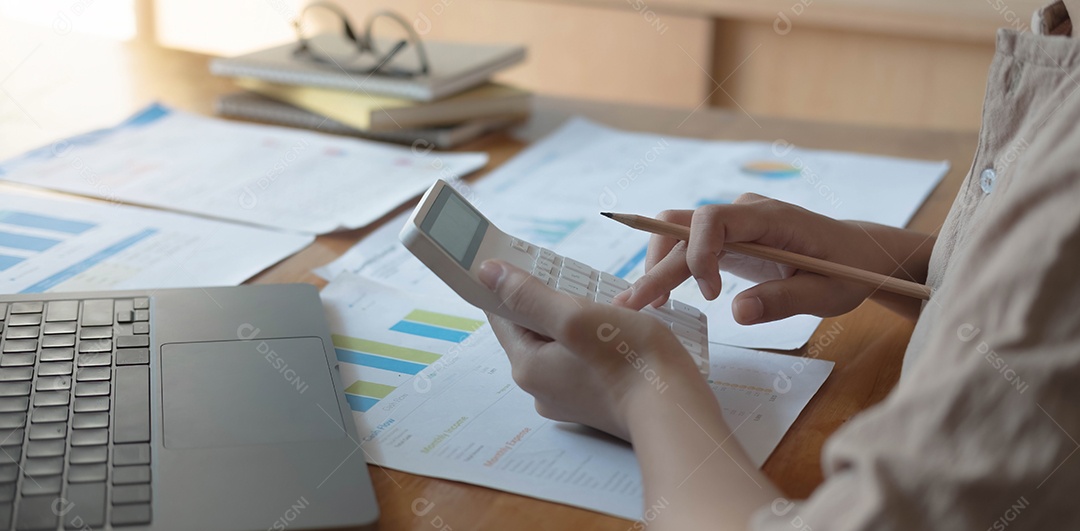 Mulher está calculando despesas de renda e analisando dados de investimento imobiliário