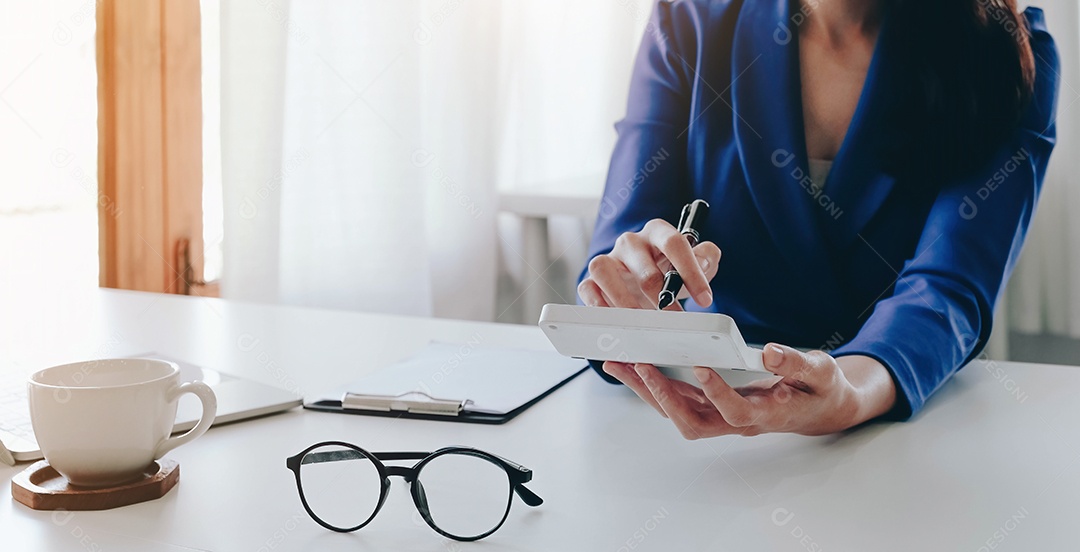 Empresária usando calculadora e laptop para cálculo