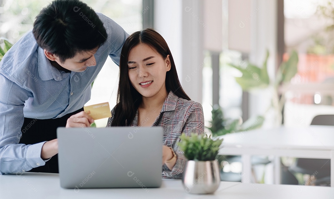 Jovem casal segurando o cartão de crédito e usando o telefone. Compras online