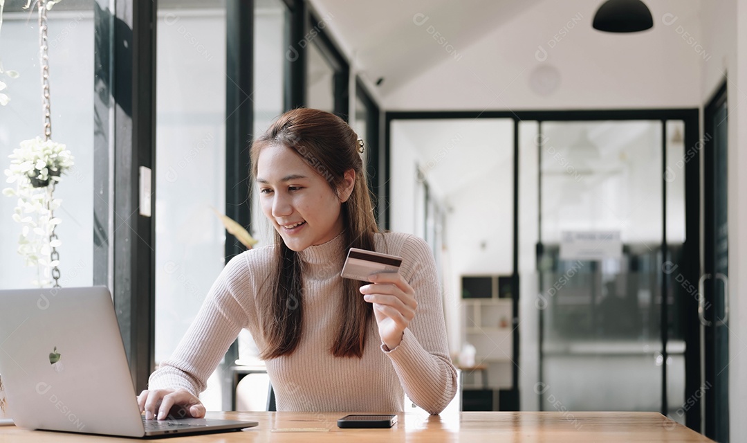 Mulher usando computador e comprando com cartão de crédito