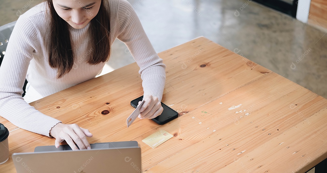Mulher usando computador e comprando com cartão de crédito