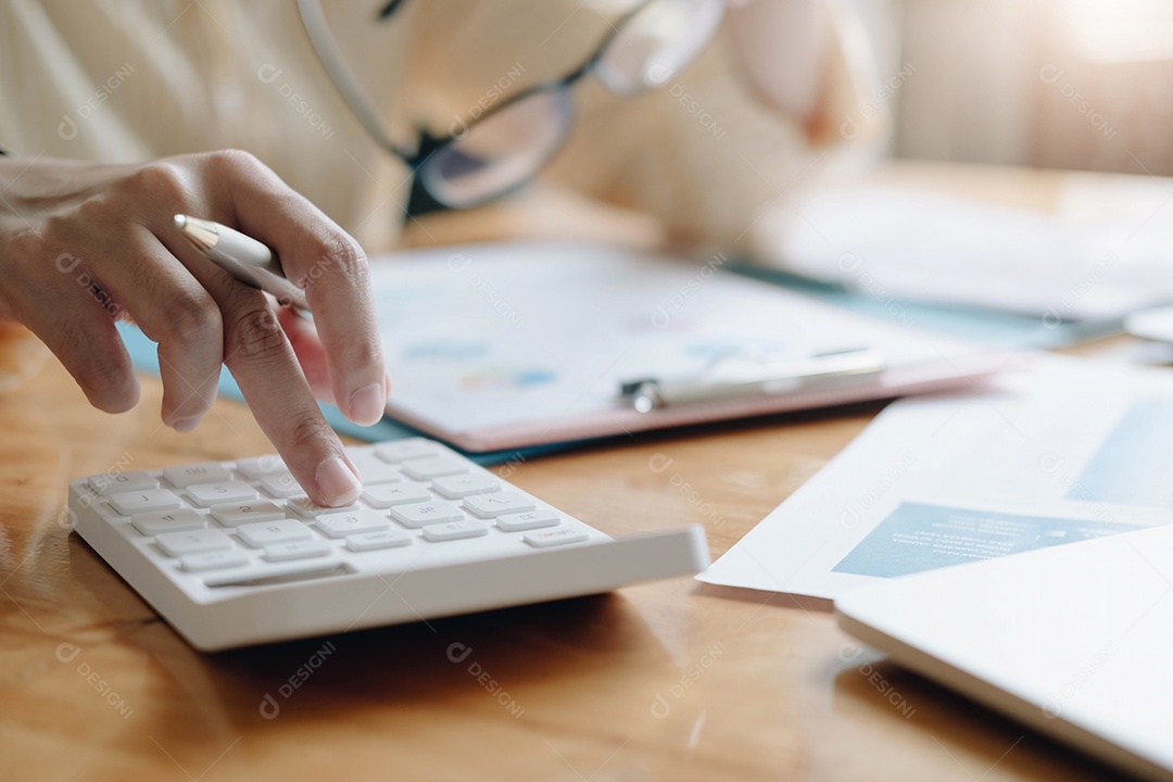 Mulher de negócios usando calculadora e laptop para fazer matemática