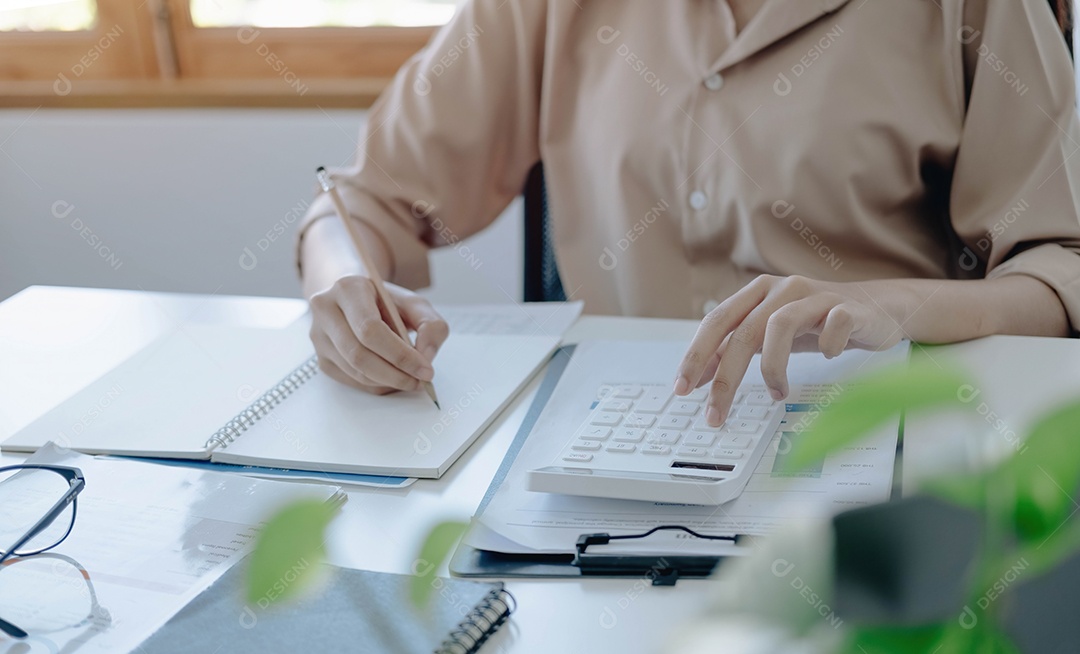 Mão da mulher usando a calculadora para calcular negócios da empresa