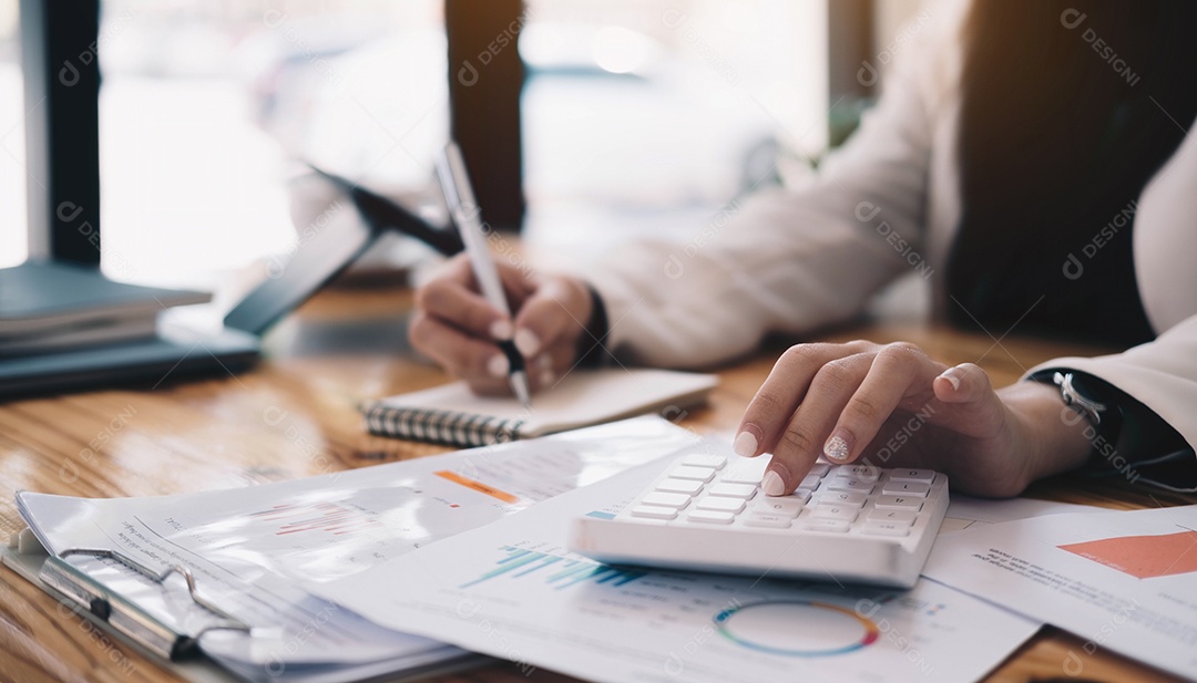 Mulher de negócios usando calculadora e escrevendo no papel