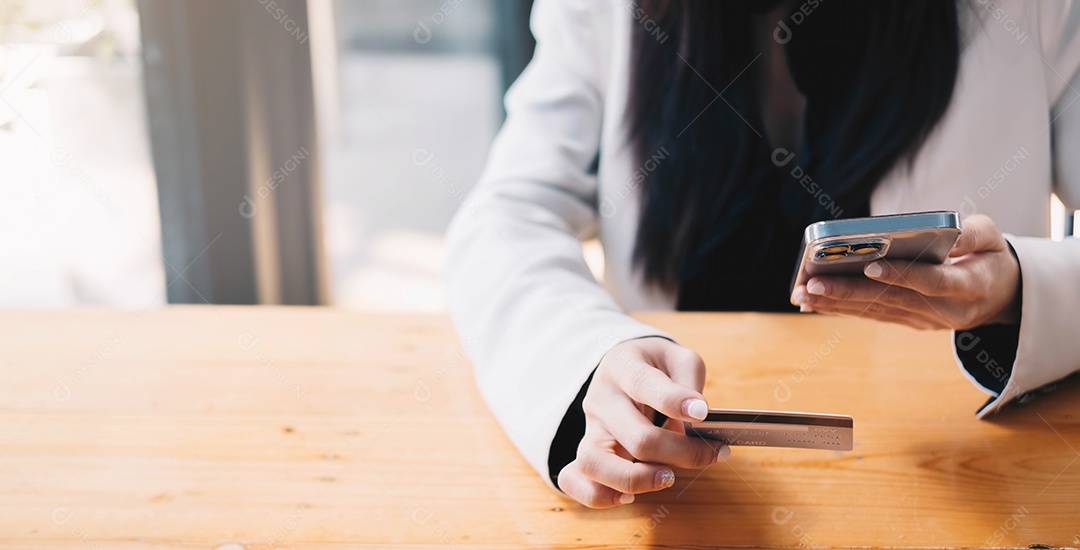 Pagamento online, mãos femininas segurando um cartão de crédito