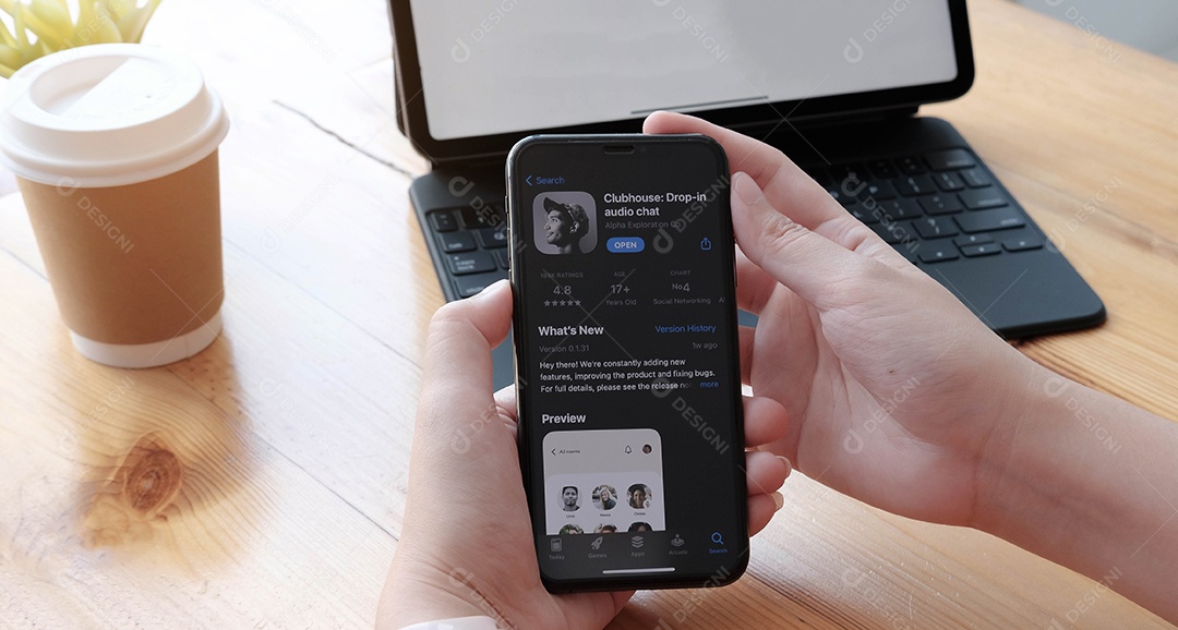 Mulher segurando Smartphone com aplicativo do Clubhouse