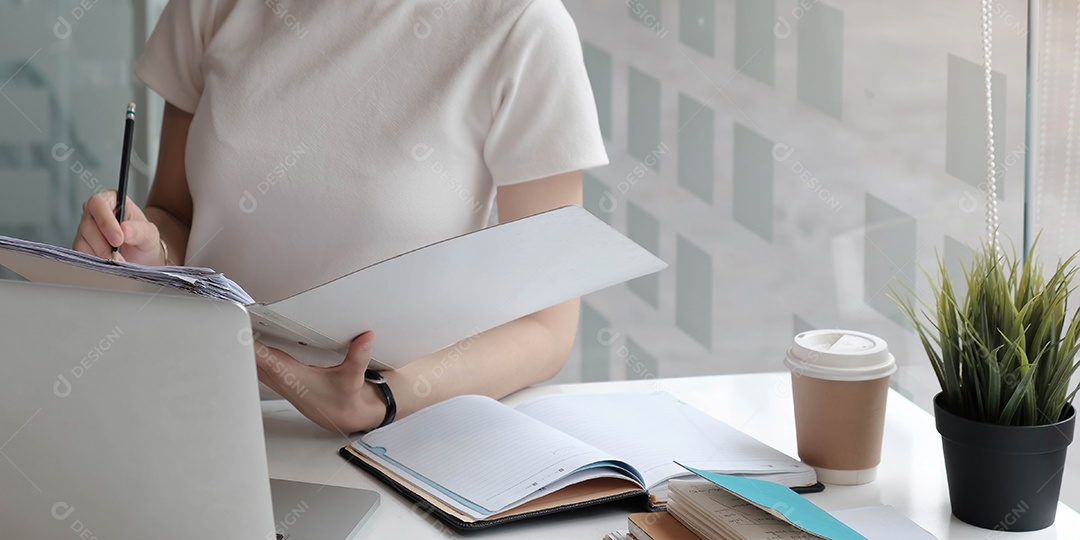 Mulher lendo papel de acordo antes de assinar documento com caneta