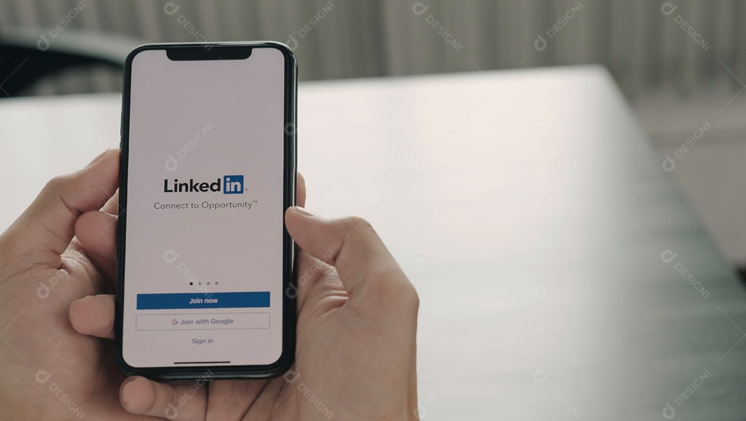 Uma mulher segura o Apple iPhone Xs com o aplicativo LinkedIn na tela