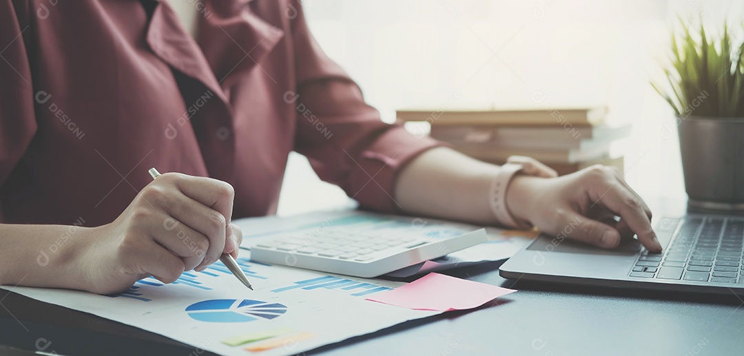 Mulher verificando a papelada do departamento de contabilidade para analisar