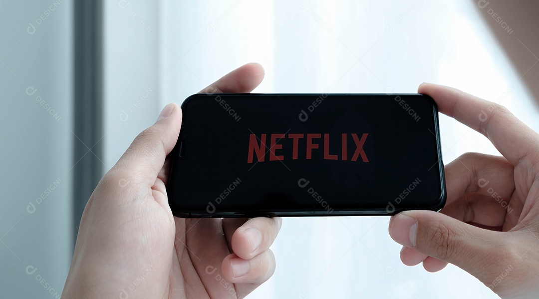 Mão de uma mulher segurando o Smartphone com logotipo da Netflix no Apple iPhone Xs.