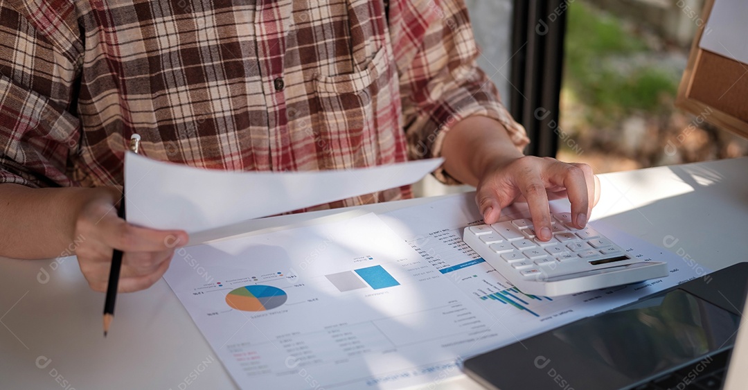 Mão do empresário ou contador segurando a caneta trabalhando
