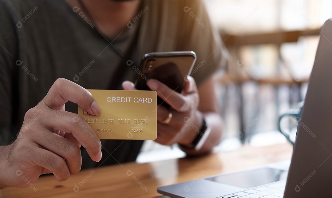 Pagamento online, as mãos do homem segurando o smartphone e usando o cartão de crédito