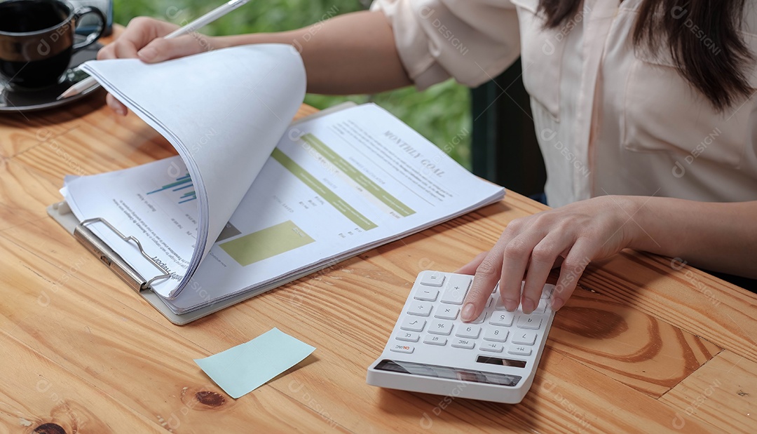 Mulher de negócios usando calculadora e laptop para fazer matemática