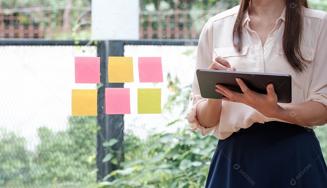 Jovem de pé e trabalhando em um laptop