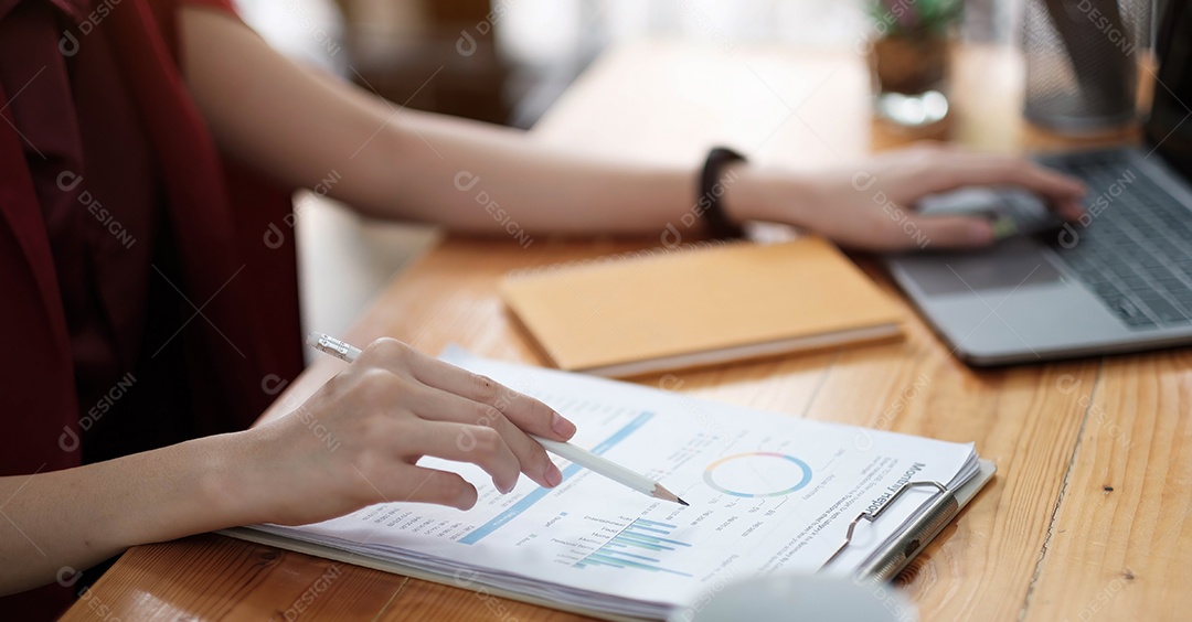 A equipe financeira masculina asiática está explicando o desempenho do gráfico de barras
