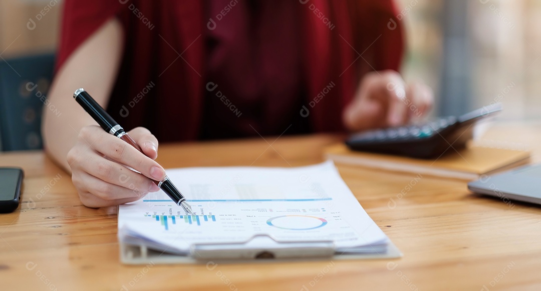 Mão da empresária ou do contador segurando a caneta trabalhando