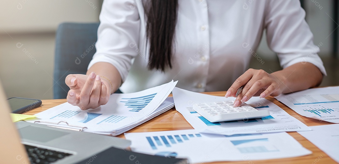 Mulher de negócios usando calculadora e laptop para fazer matemática