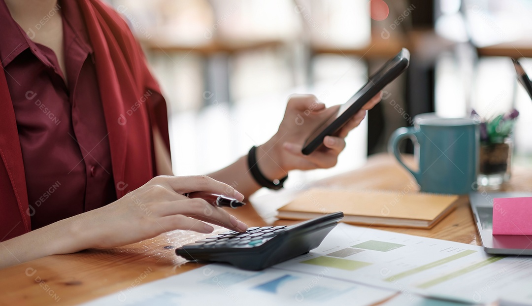 Mulher de negócios usando calculadora e laptop para fazer matemática