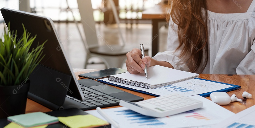 Mulher asiática está fazendo anotações em seu caderno