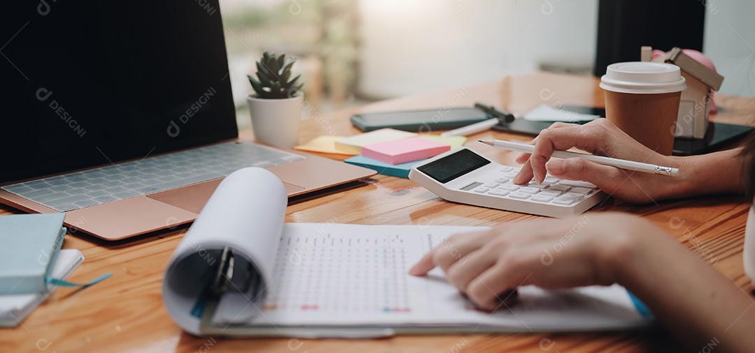 Empresária usando calculadora e laptop para cálculos