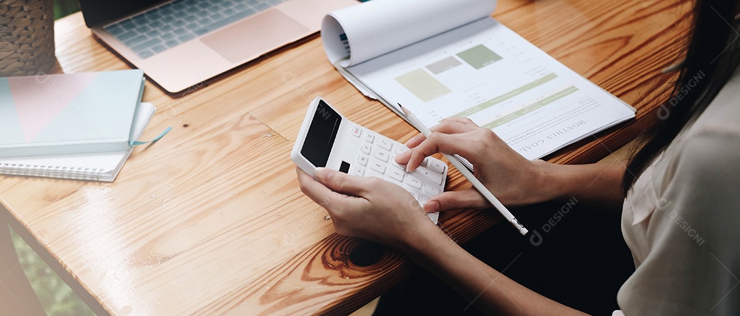 Mulher de negócios usando calculadora e laptop para fazer matemática