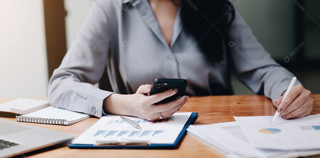 Mãos de mulheres usando análise de smartphone e laptop