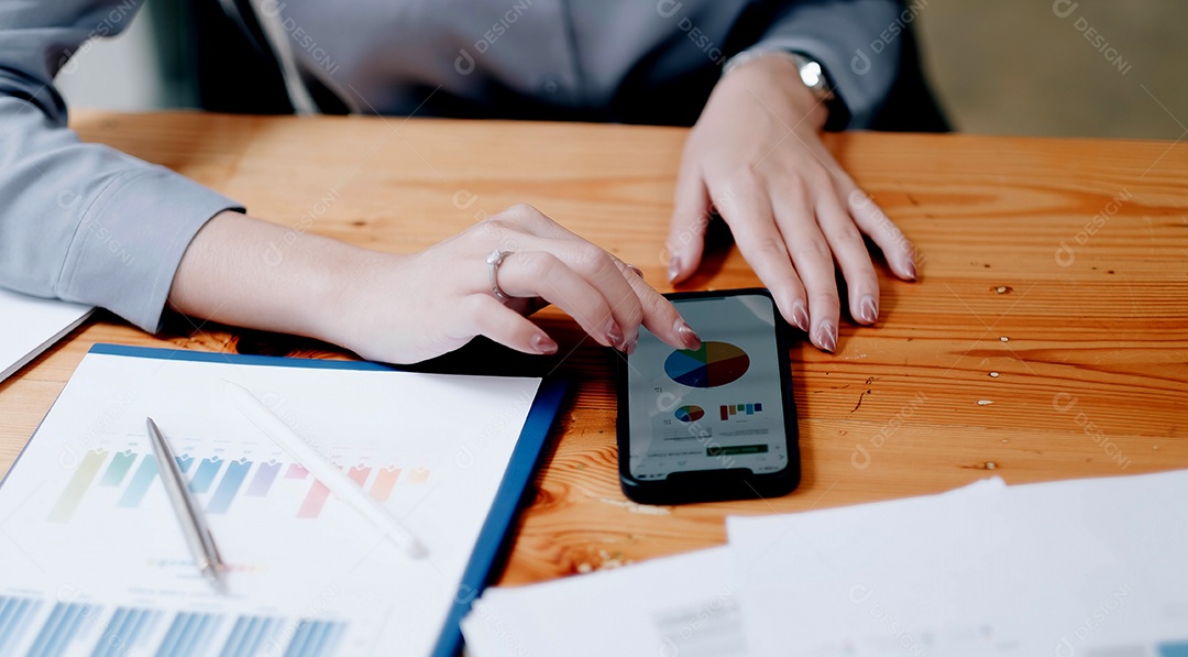 Mulher de negócios usando smartphone para analisar dados financeiros.