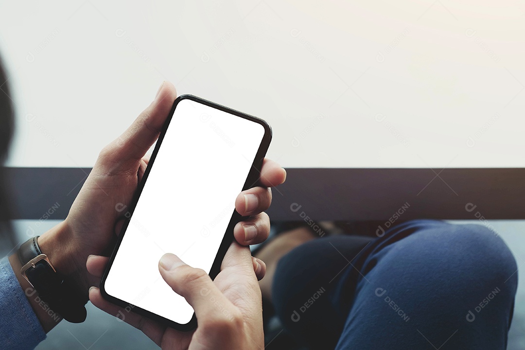 Homem de vista superior sentado e segurando a maquete de tela em branco do telefone