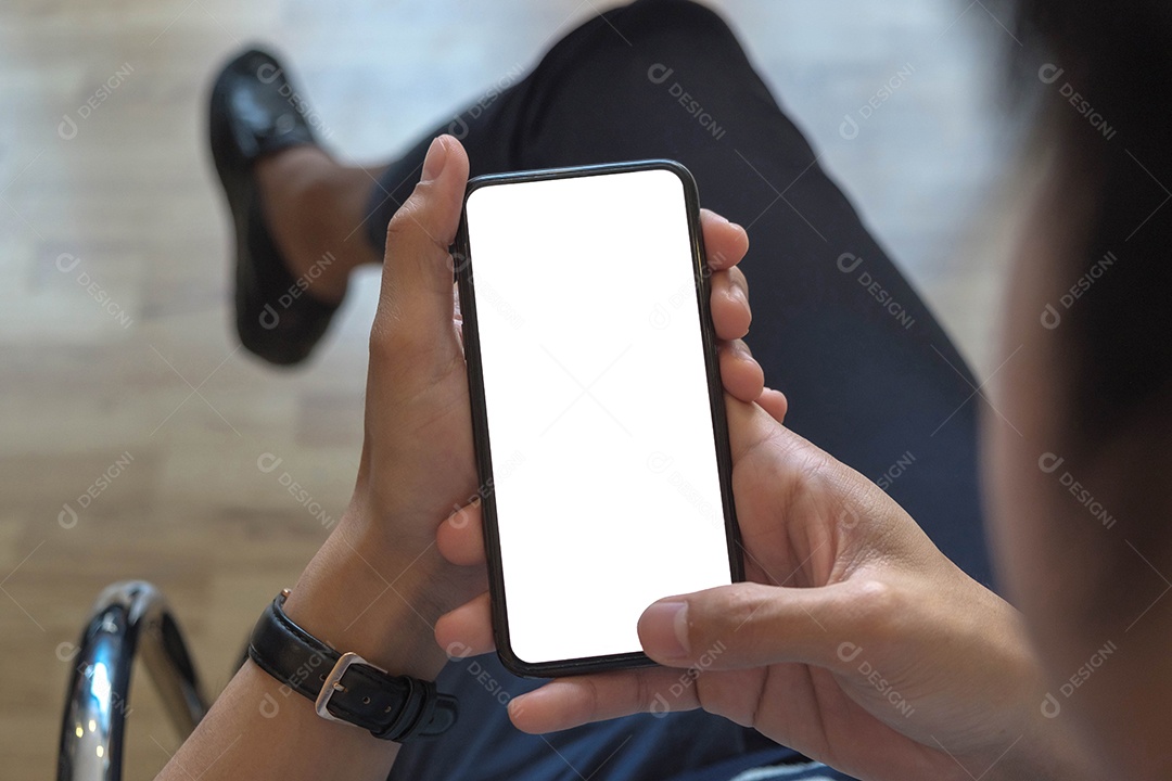 Homem segurando o telefone inteligente com fundo desfocado.