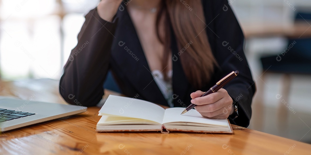 Mãos da mulher com laptop, caderno e caneta