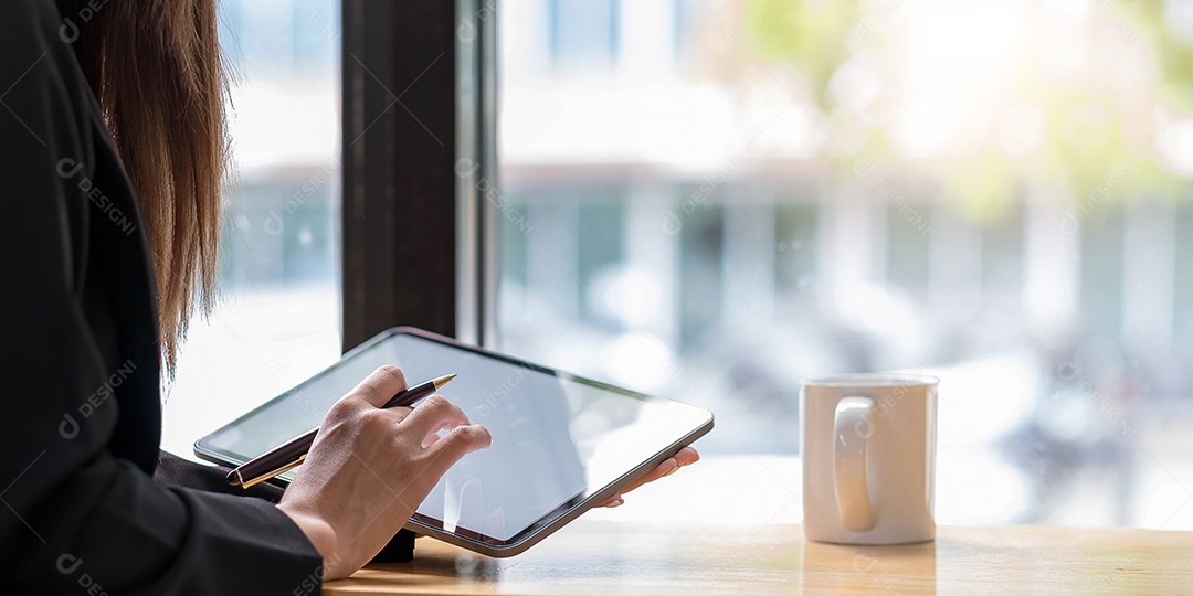 Vista superior de uma mulher segurando um tablet digital e uma caneta stylus