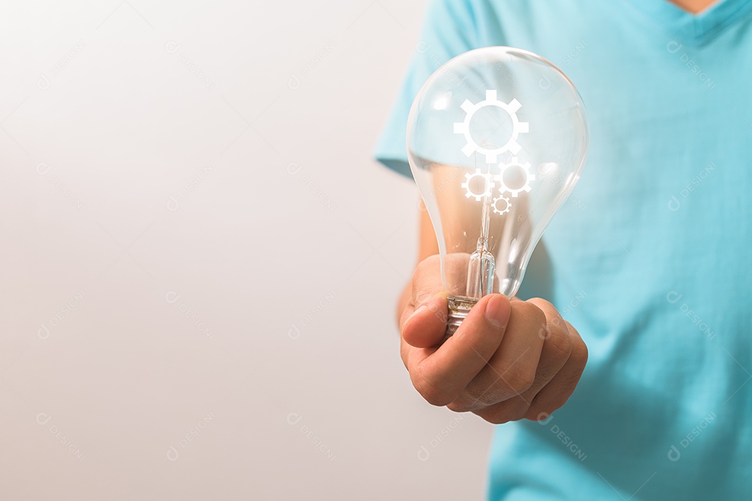 Homem segurando uma lâmpada com um símbolo de engrenagem