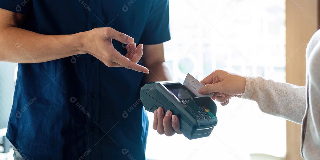 Mão do cliente pagando com cartão de crédito sem contato com NFC