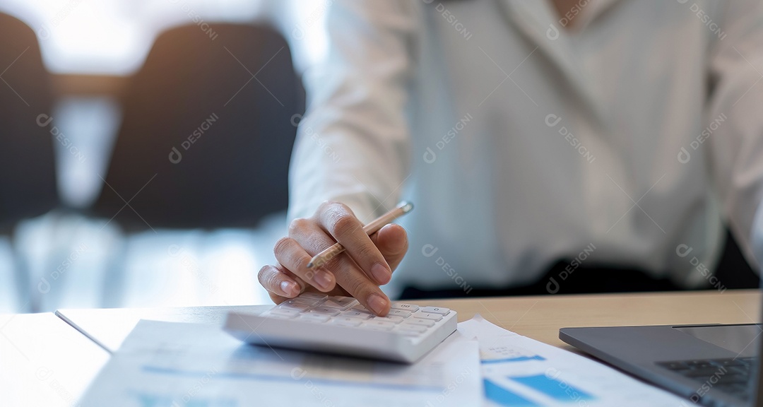 Mulher de negócios usando calculadora e laptop para fazer matemática