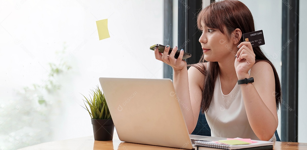 Mulher sorridente sentada no escritório falando no celular