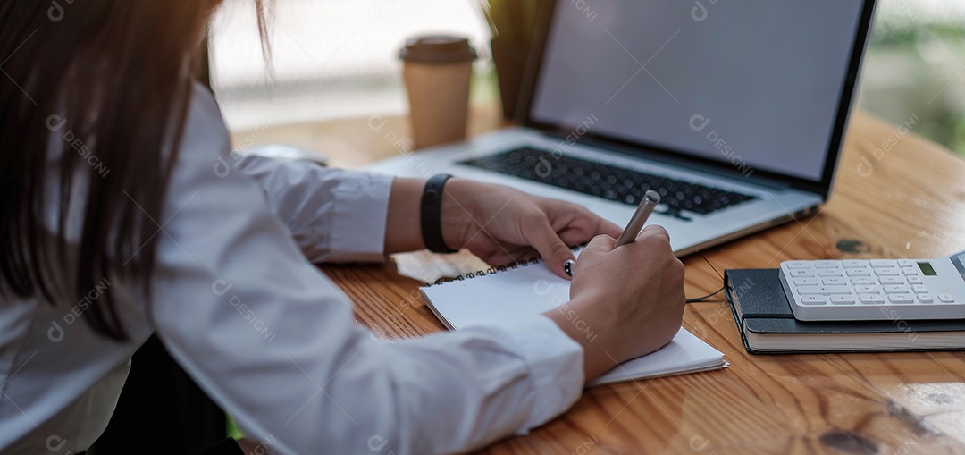 Mãos da mulher usando laptop e escrevendo