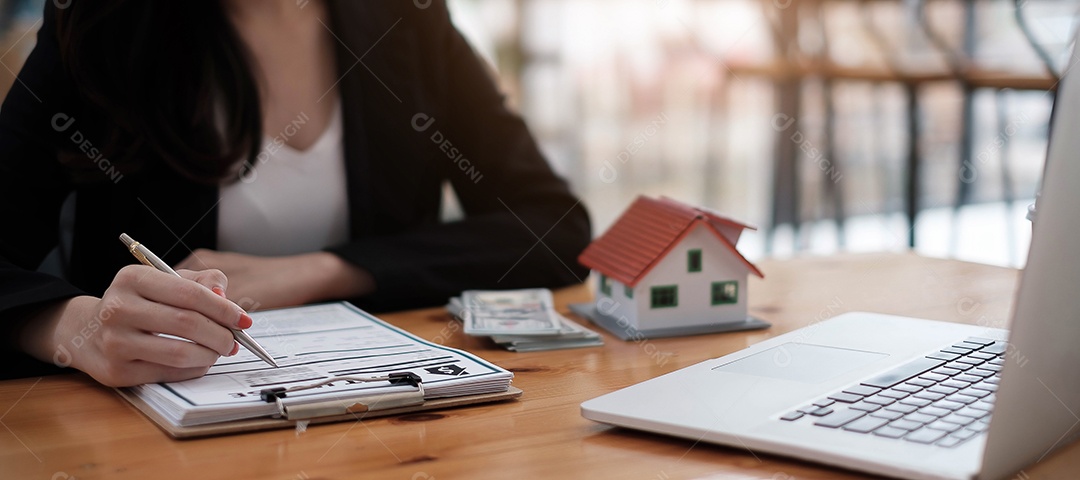 Mãos da empresária assinando documento de locação de casa