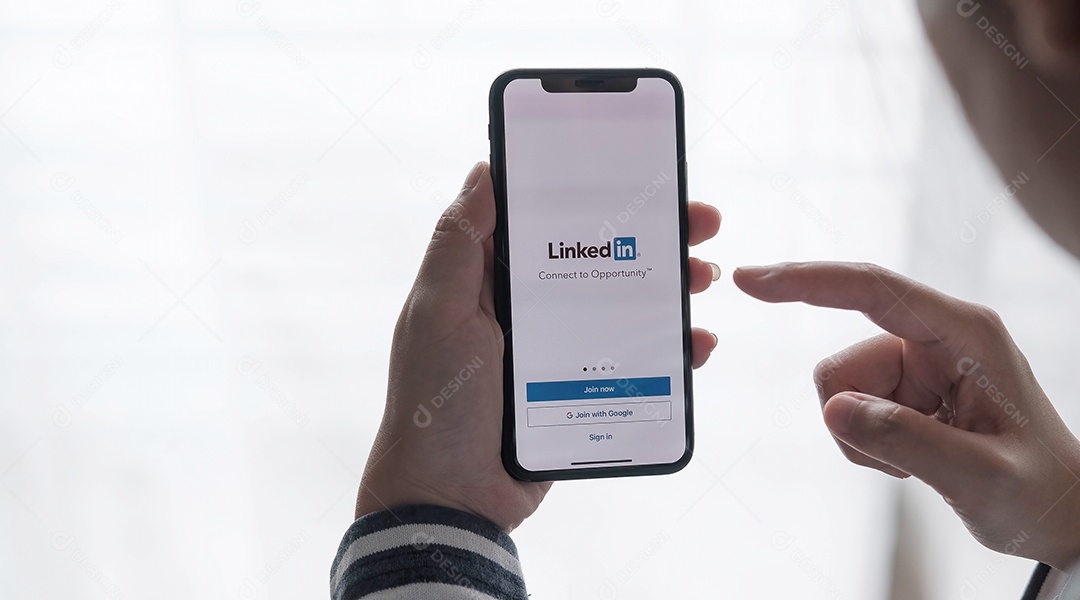 Uma mulher segura o Apple iPhone Xs com o aplicativo LinkedIn na tela.