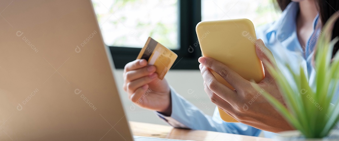 Mãos de mulher, pagamento online usando cartão de crédito para compras.